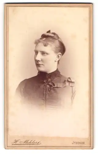 Fotografie H. Mehlert, Itzehoe, Breite Strasse 14, Junge Dame mit Stirnlocken und Dutt, Seitenportrait