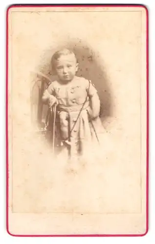 Fotografie A. F. Knoop, Eutin, Kleinkind im kurzärmeligen Kleiudchen