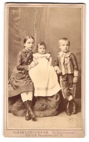 Fotografie Albert Grundner, Berlin, Potsdamer-Str. 111, Mädchen und Junge mit Kleinkind in hübscher Kleidung