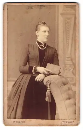 Fotografie H. Mehlert, Itzehoe, Breitestr. 14, Junge Dame im Kleid mit Buch