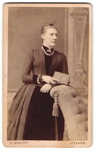 Fotografie H. Mehlert, Itzehoe, Breitestr. 14, Hübsche Dame im Kleid mit Buch