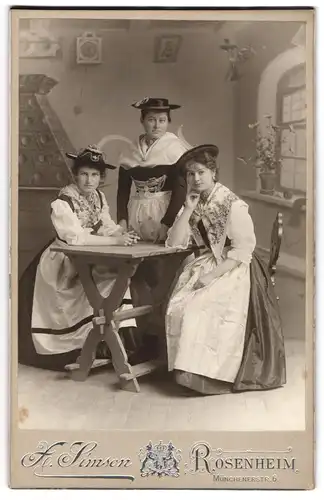 Fotografie X. Simson, Rosenheim, drei Damen in bayrischer Tracht Dirndl posieren in einer Studiokulisse, 1903