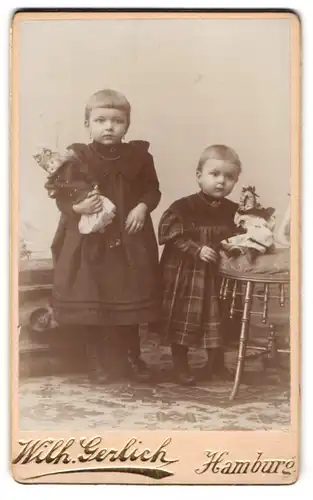 Fotografie Wilh. Gerlich, Hamburg, zwei niedliche Mädchen mit ihren Puppen im Atelier, 1899