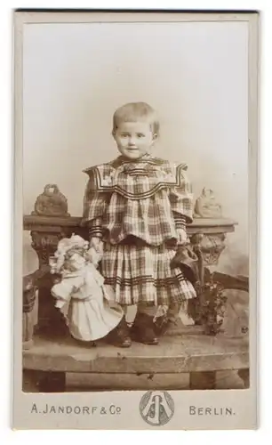 Fotografie A. Jandorf & Co., Berlin, kleines Mädchen im karierten Kleid mit ihrer Puppe auf einer Bank