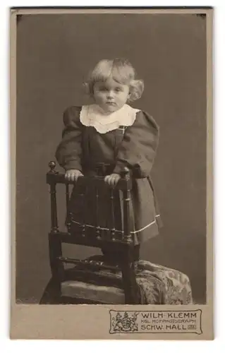 Fotografie Wilh. Klemm, Schw. Hall, süsses blondes Mädchen im Kleidchen auf einem Stuhl stehend