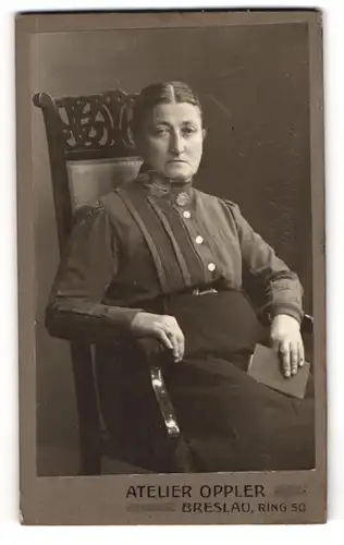 Fotografie Atelier Oppler, Breslau, Ring 50, Portrait einer elegant gekleideten Frau im Stuhl sitzend