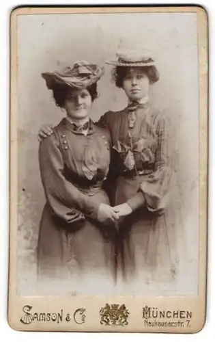 Fotografie Samson & Co., München, Neuhauserstrasse 7, Zwei Damen in taillierten Kleidern mit modischen Hüten