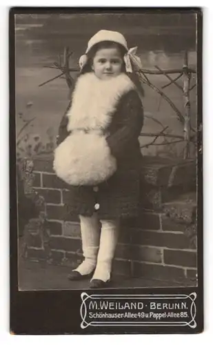 Fotografie M. Weiland, Berlin, süsses Mädchen im Winter Wollkleid mit Pelzmuff und Mütze