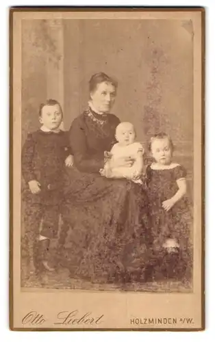 Fotografie Otto Liebert, Holzminden, Mutter mit zwei Kindern und Säugling im Sonntagsstaat