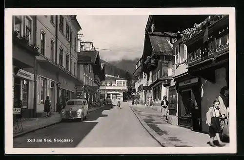 AK Zell am See, Seegasse mit Geschäften, Passanten und Oldtimern