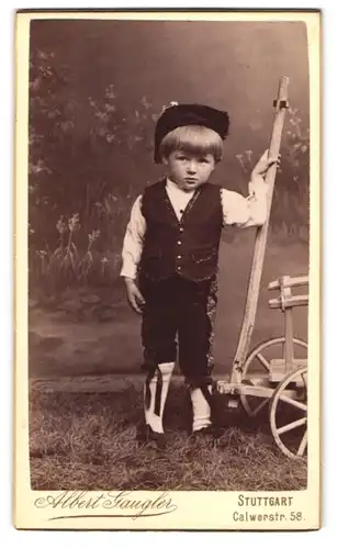 Fotografie Albert Gaugler, Stuttgart, Portrait niedlicher Knabe Walter im Trachtenkostüm zum Fasching mit Bollerwagen