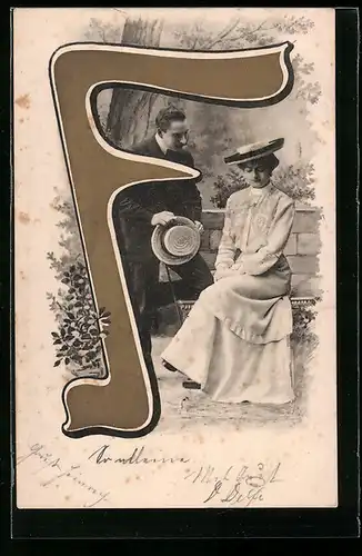 AK Paar vor einer Mauer am Buchstaben F