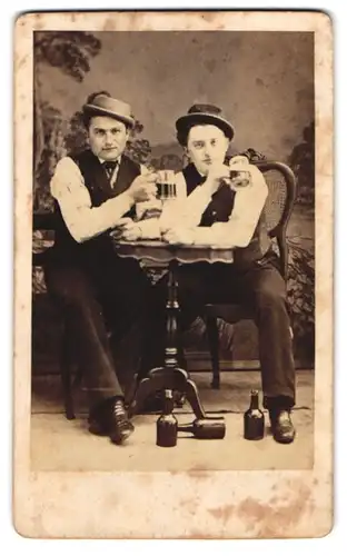 Fotografie unbekannter Fotograf und Ort, zwei junge Herren beim Umtrunk mit Schwarzbier im Atelier