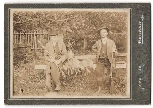 Fotografie unbekannter Fotograf und Ort, zwei Jäger mit Flinte und erlegter Beute, Hasen und Wachtel