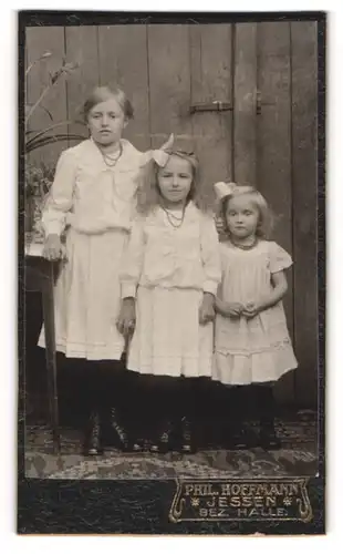 Fotografie Phil. Hoffmann, Jessen, drei kleine Mädchen in weissen Kleidern posieren der Grösse nach