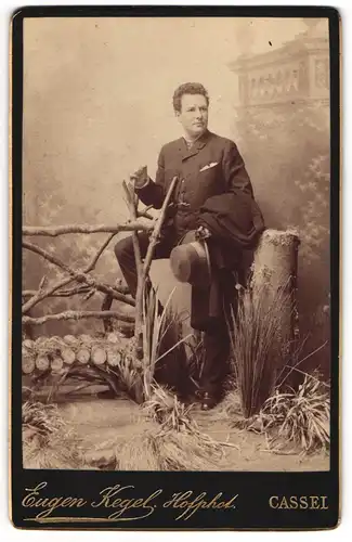 Fotografie Eugen Kegel, Cassel, junger Mann im Anzug posiert in einer Studiokulisse