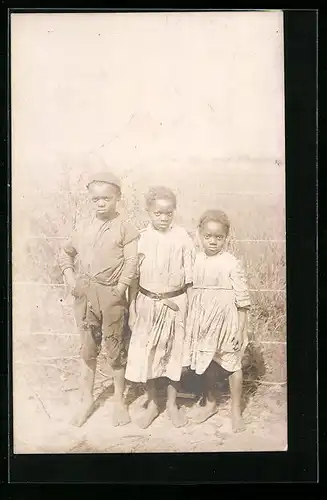 AK Drei Kinder vor einem Zaun