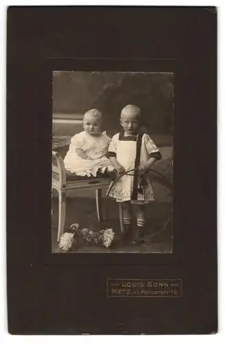 Fotografie Louis Bonn, Metz, Kl. Pariserstr. 10, Baby im Kleidchen nebst Knabe mit Reif 1910