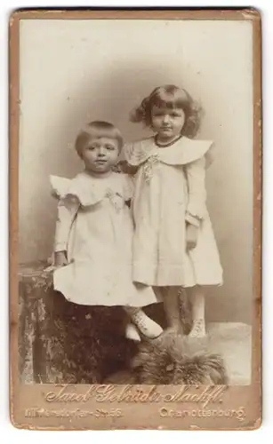Fotografie Jacob Gebrüder Nachf., Charlottenburg, zwei niedliche Mädchen in weissen Kleidern, Locken