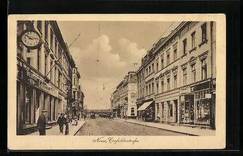 AK Neuss, Geschäfte in der Crefelderstrasse mit Blick zur Eisenbahnbrücke
