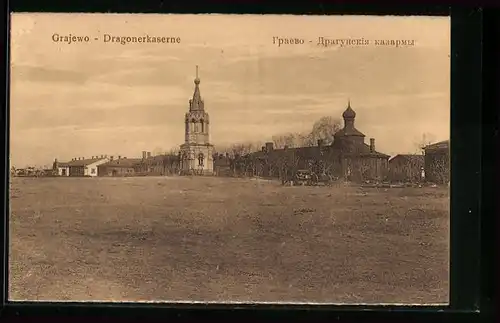 AK Grajewo, Dragonerkaserne mit Kirchen, von einer Freifläche gesehen