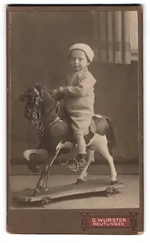 Fotografie G. Wurster, Reutlingen, junger Knabe sitzt auf seinem Schaukelpferd mit Rädern