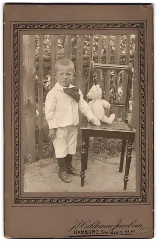 Fotografie J. Waldemar Jacobsen, Hamburg, junger Knabe mit seinem Teddybär auf dem Stuhl