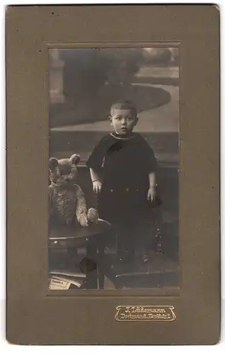 Fotografie J. Lüdemann, Dortmund, kleines Kind mit Teddybär auf dem Tisch