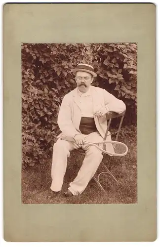 Fotografie unbekannter Fotograf und Ort, Tennisspieler im weissen Anzug mit Tennisschläger und Zigarre
