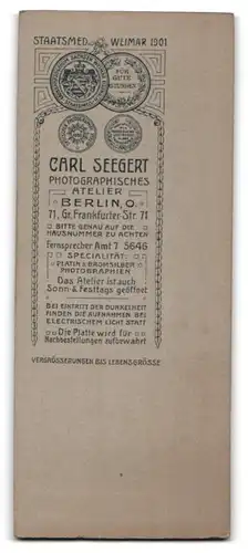 Fotografie Carl Seegert, Berlin, Gr. Frankfurter-Str. 71, Junger Herr im Mantel lehnt am Tisch