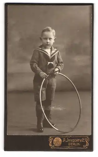 Fotografie A. Jandorf & Co., Berlin, Bellealliancestr. 1-2, Kleiner Junge im Matrosenanzug mit Reifen