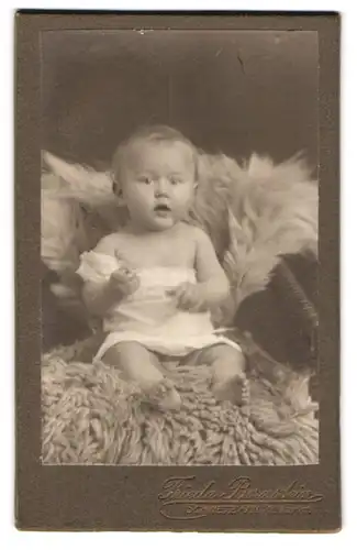 Fotografie Frieda Bernstein, Schwetz a. W., Kl. Markt, Süsses Kleinkind im Hemd mit nackigen Füssen