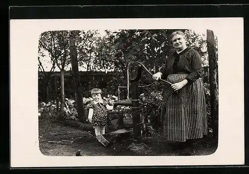 Foto-AK Frau und kleines Kind an der Wasserpumpe im Garten