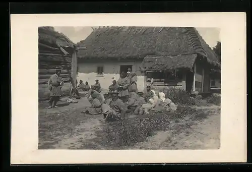 Foto-AK Kleine Versammlung auf dem Boden zwischen Häusern