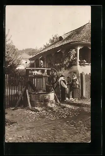 AK Ortspartie mit Rumänninnen vor Bauernhaus und Brunnen