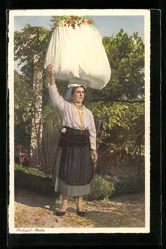 AK Porto, Eine Frau in portugiesischer Tracht trägt einen Wäschesack auf dem Kopf