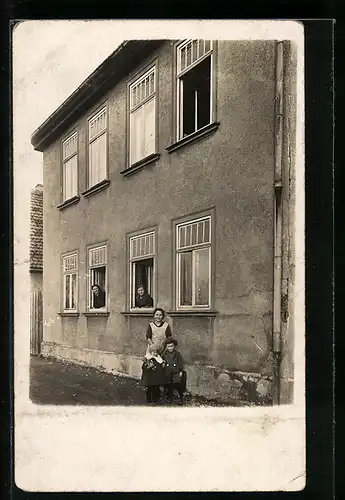 Foto-AK Ilmenau, Frau mit Kindern vor einem Haus, Bewohnerinnen in Fenstern
