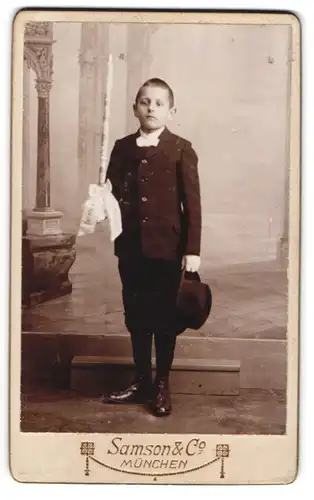 Fotografie Samsons & Co., München, junger Knabe im Anzug mit Kommunionskerze