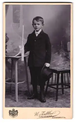 Fotografie U. Zattler, Landshut i. B., junger Knabe zu seiner Erstkommunion mit Kerze