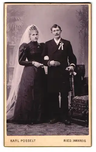 Fotografie Karl Posselt, Ried, Ehepaar im schwarzen Brautkleid mit weissem Schleier und im dunklen Anzug