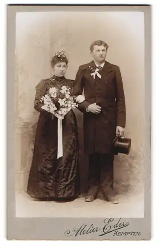Fotografie Atelier Eder, Kempten, junge Eheleute im schwarzen Brautkleid und im Anzug, Brautstrauss und Zylinder