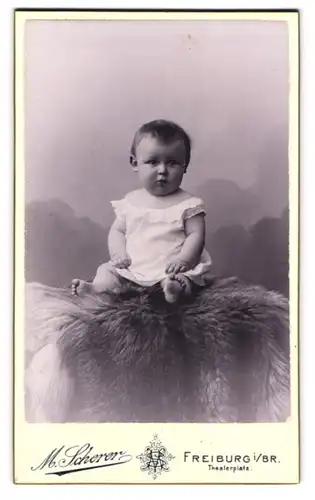 Fotografie M. Scherer, Freiburg i. Br., Theaterplatz, Süsses Kleinkind im Hemd mit nackigen Füssen