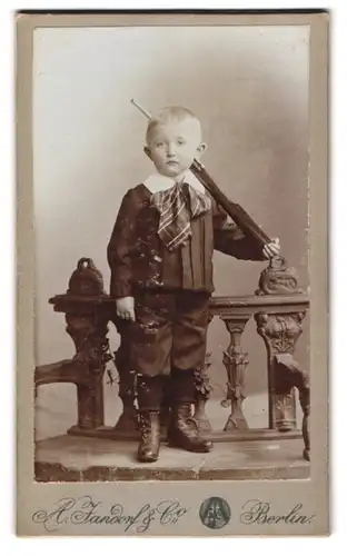 Fotografie A. Jandorf & Co., Berlin, Bellealliancestr. 1-2, Modisch gekleideter Junge mit Gewehr