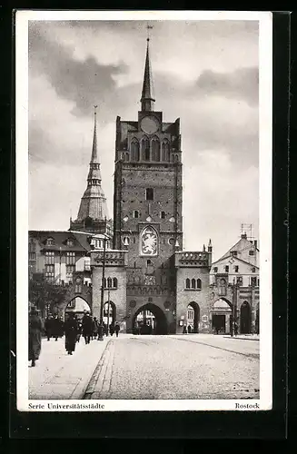 AK Rostock, Strassenpartie mit Tor und Kirche