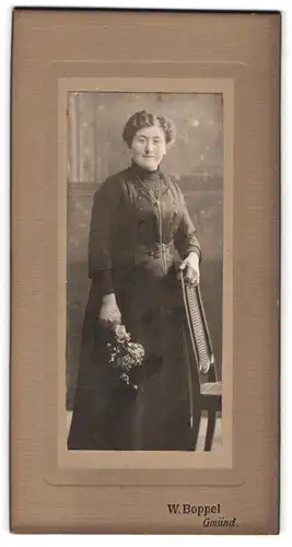 Fotografie W. Boppel, Gmünd, Bürgerliche Dame in edlem Kleid mit Blumenstrauss