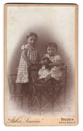 Fotografie E. Uhlmann, Dresden, Ostra-Allee 8, Zwei Kinder in karierten Kleidern mit Puppe