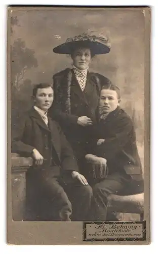 Fotografie H. Behning, Buxtehude, Bürgerliche Dame mit zwei jungen Männern