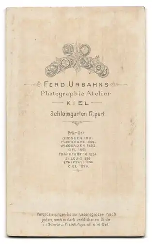 Fotografie Ferd. Urbahns, Kiel, Schlossgarten 17, Dame mit Kopfbedeckung, Puffärmeln und Brosche