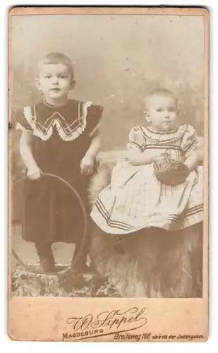 Fotografie W. Sippel, Magdeburg, Breiteweg 168, Zwei Kinder in Kleidern mit Reifen