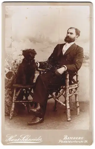 Fotografie Hans Schneider, Bamberg, Herr im feinen Anzug mit seinem struppigen Hund auf einem Hocker